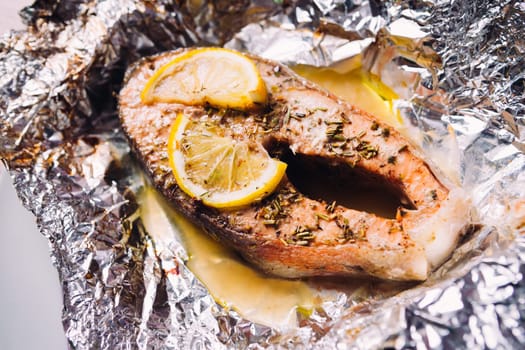 fish steak baked with lemon and herbs in foil