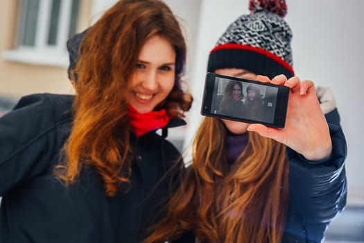 Two beautiful girls doing selfie on white background