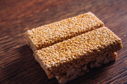 Kozinaki of sesame and peanut on a wooden background