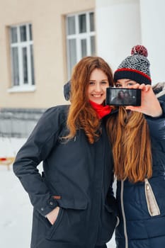 Two beautiful girls doing selfie on white background