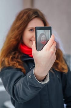 girl doing selfie on the background of city architecture