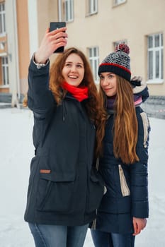 Two beautiful girls doing selfie on white background