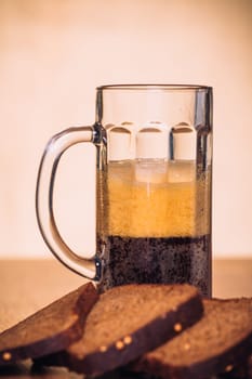 Russian brew in mug and loaf of rye flour on wooden background