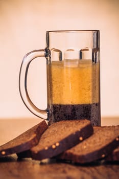 Russian brew in mug and loaf of rye flour on wooden background