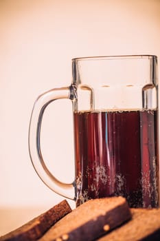 Russian brew in mug and loaf of rye flour on wooden background