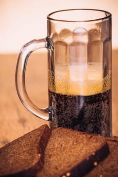 Russian brew in mug and loaf of rye flour on wooden background