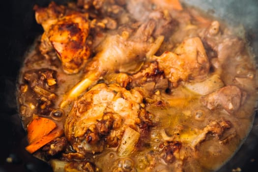 chicken in sauce with carrots in a pan closeup