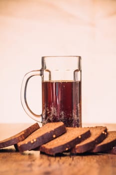 Russian brew in mug and loaf of rye flour on wooden background