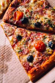 pieces of pizza with olives, cheese and salami sausage