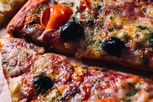 pieces of pizza with olives, cheese and salami sausage