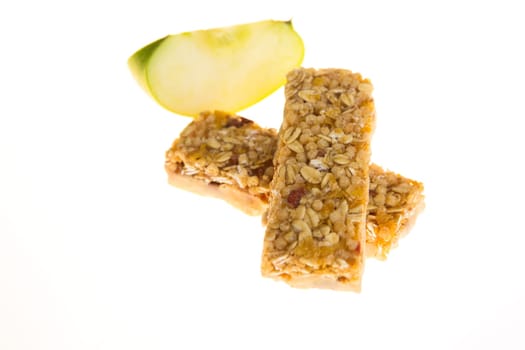 muesli bars with dried fruit on isolated background with apple