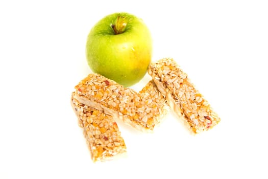 muesli bars with dried fruit on isolated background with apple