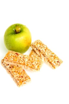 muesli bars with dried fruit on isolated background with apple