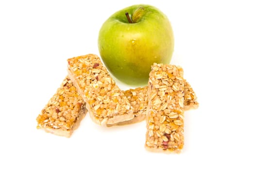 muesli bars with dried fruit on isolated background with apple