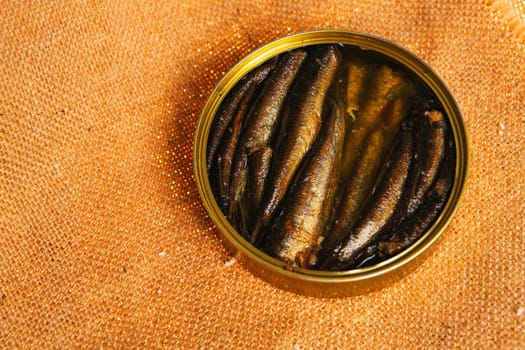 open can with of sprats on sackcloth background