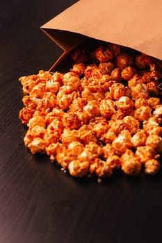 many popcorn in a paper bag on a dark background