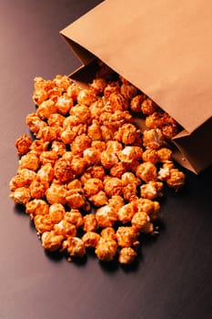 many popcorn in a paper bag on a dark background