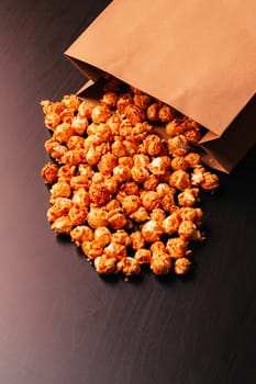 many popcorn in a paper bag on a dark background