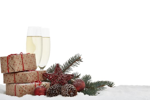 Still life with champagne bottle standing in a bucket with ice, two full champagne flutes, gift box and Christmas ornaments. Christmas and New Year background with copy space. Greeting card