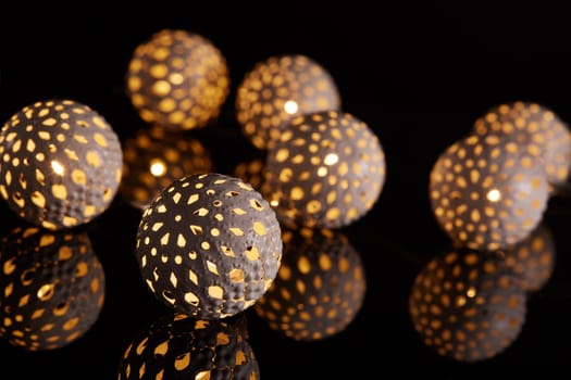 Decorative LED lights garland on a black background with reflection. New Year and Christmas background