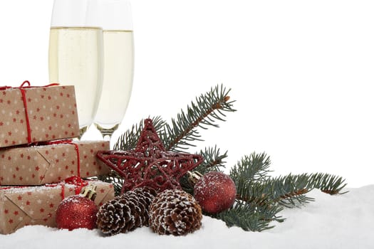 Still life with champagne bottle standing in a bucket with ice, two full champagne flutes, gift box and Christmas ornaments. Christmas and New Year background with copy space. Greeting card