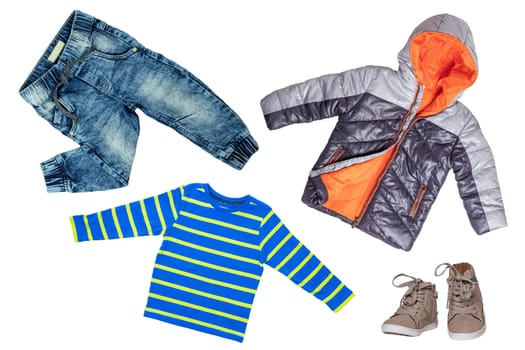 Top view on child boy set of clothes. Collage of apparel clothing. Jeans , shirt, shoes and warm down jacket isolated on a white background. Autumn and winter fashion.