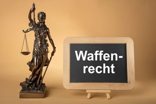 Justizia Figure with chalkboard with german text: Weapons Legally on beige Background