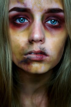 Young blond woman, sfx zombie makeup with blue eyes