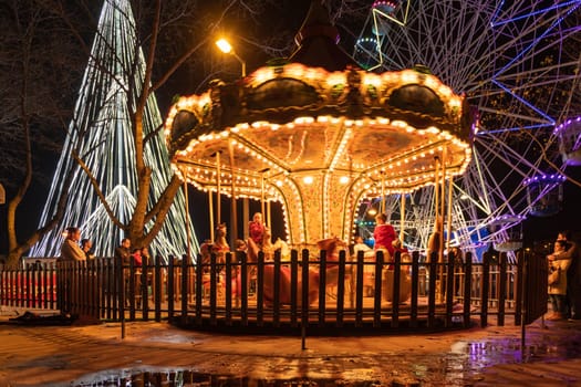 AVEIRO, PORTUGAL - CIRCA DECEMBER 2018: Fonte Nova's garden with Christmas market and colored ferris wheel near Ria de Aveiro at night.