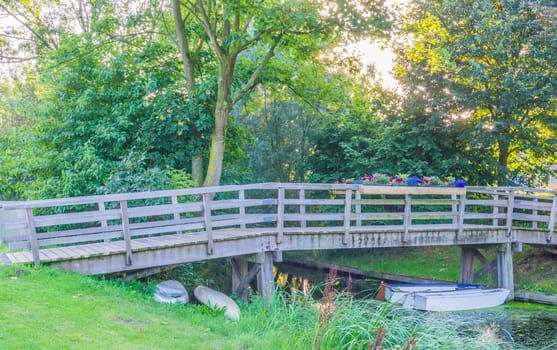wooden bridge with river in a forest landscape with boats