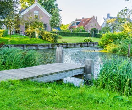 wooden pier at a pond with view on the village houses