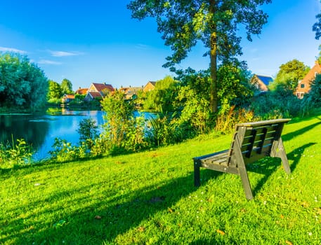 tiny wooden park bench at the park pond beautiful landscape photo