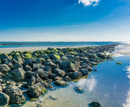 straight line of stacked rocks on the beach with a ocean view
