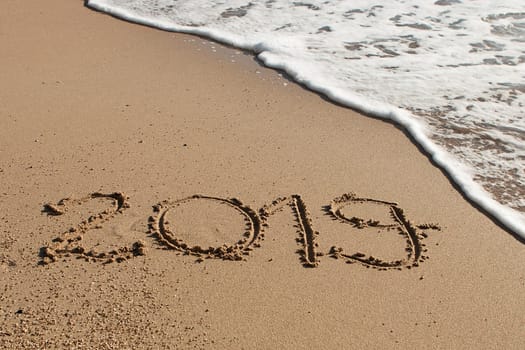 Year 2019 written in the sand on the beach