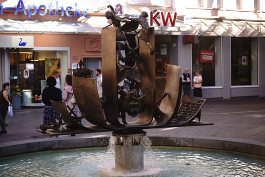 Worms, Germany - October 13, 2018: The Nibelungenlied fountain by the artist Gustav Nonnenmacher in the pedestrian zone of the city center on October 13, 2018 in Worms..