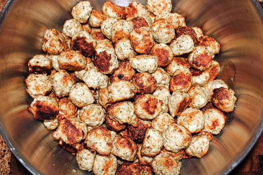 Baked meatballs piled into a silver pot.