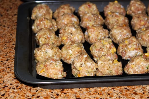 view of raw turkey pine nut meatballs on cookie sheets.