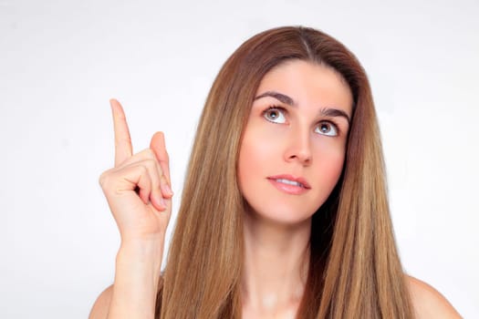 Beautiful woman with index finger looks up