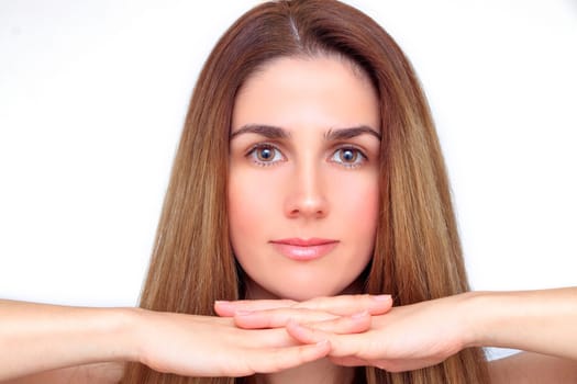 Beautiful face of a woman with hands under her chin