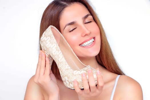 Beautiful happy woman with high heels in hear hands