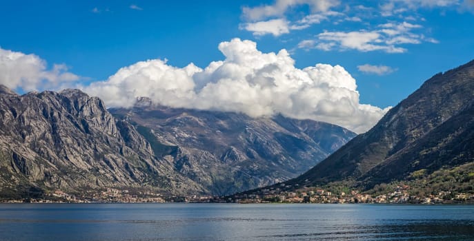 Stunning panoramic landscape of the sea and mountains in the Bay of Kotor as seen from the shore in Perast town, Montenegro
