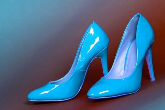 The blue high heels shoes are on brown and blue background.
