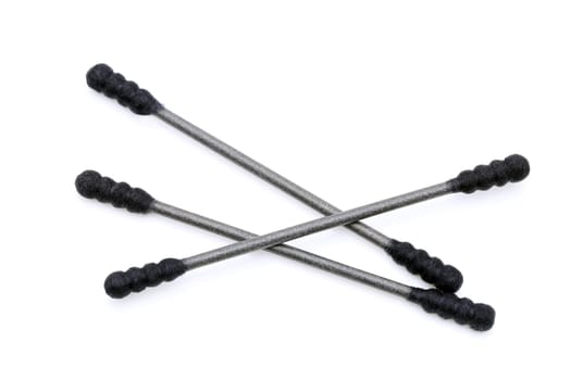 Black cotton swabs on a white background, close up