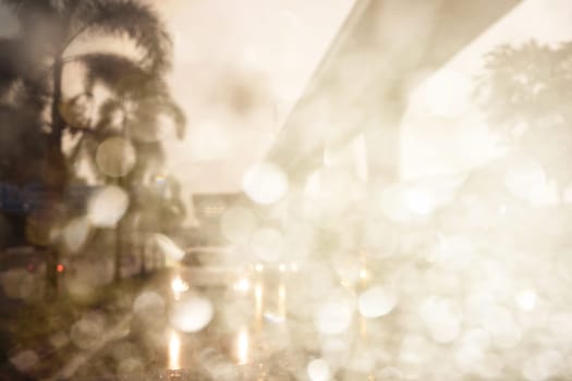 Abstract defocused bokeh road view through car window blurry with rain drops bokeh.