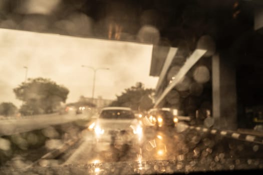 Traffic in heavy rainy day with road view inside the car window with rain drops.