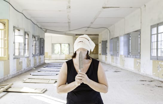 Murderer in abandoned house with a knife, halloween