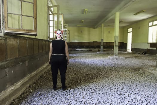 Clown in abandoned house and ruined halloween
