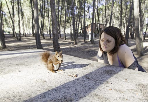 Girl with squirrel in forest with trees, nature