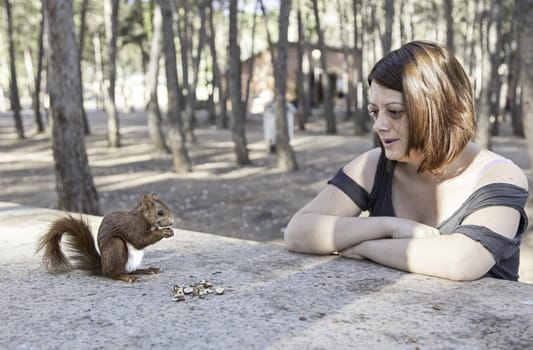Girl with squirrel in forest with trees, nature