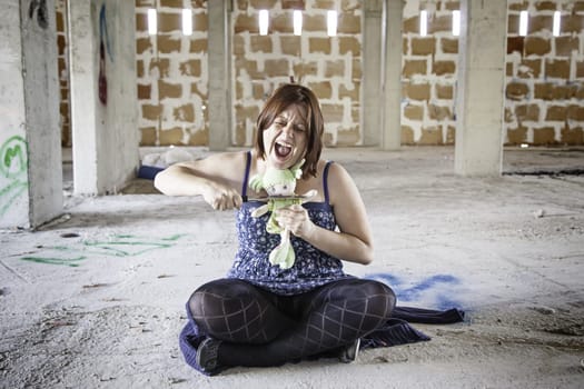 Woman with knife in abandoned house, fear and halloween
